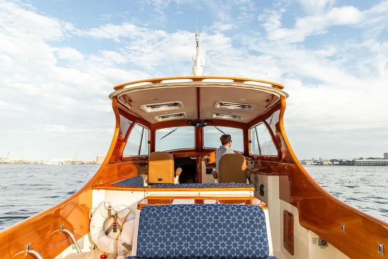 Slide: The Image of 2002 Hinckley Picnic Boat 36 EP cruising on open water under a clear sky. - 6