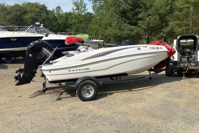 The Image of 2022 Tahoe T16 boat on trailer, parked outdoors with trees in background. - 0
