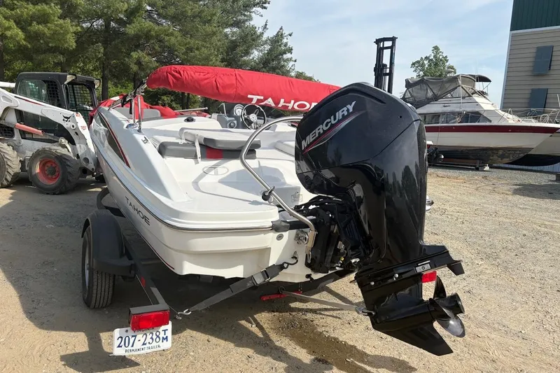 Slide: The Image of 2022 Tahoe T16 boat with Mercury outboard motor on trailer, parked outdoors. - 5