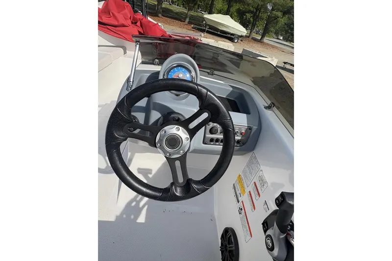 Slide: The Image of Steering wheel and dashboard of a 2022 Tahoe T16 boat, featuring control panel and gauges. - 7