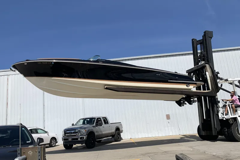 The Image of 2022 Chris-Craft Corsair 34 boat lifted by forklift near warehouse. - 0