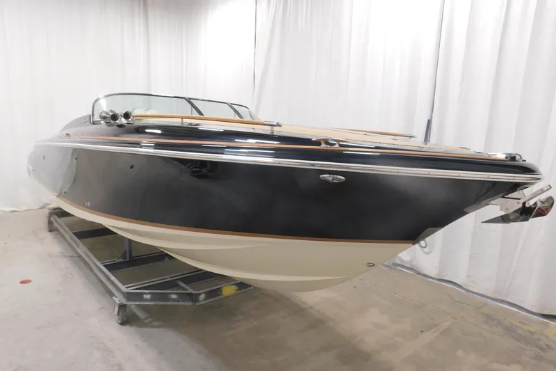 Slide: The Image of 2022 Chris-Craft Corsair 34 boat in showroom, sleek design, black and white finish. - 23