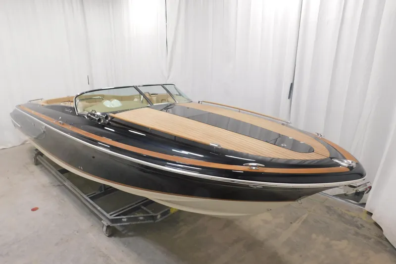 Slide: The Image of 2022 Chris-Craft Corsair 34 boat with sleek design and wooden deck in showroom. - 24
