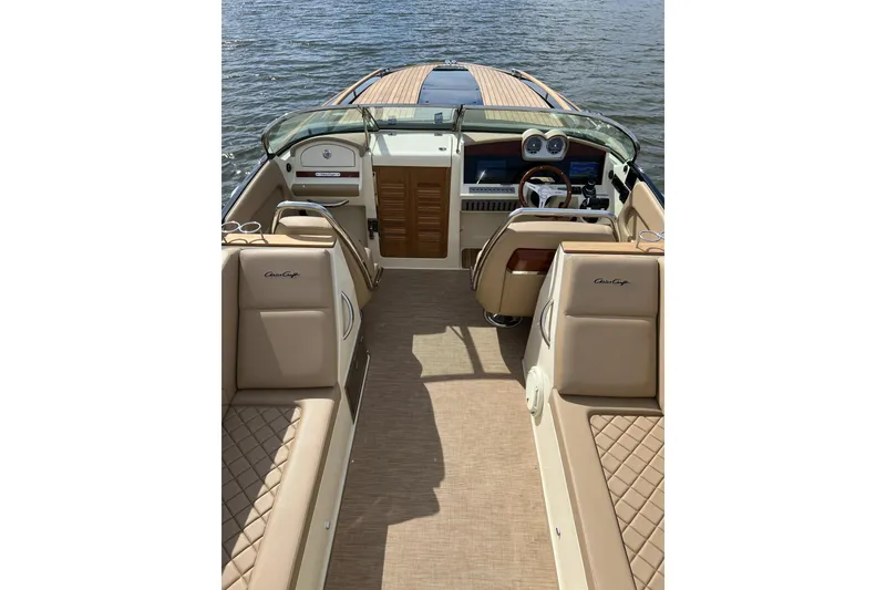 Slide: The Image of 2022 Chris-Craft Corsair 34 boat interior with luxurious seating and dashboard, on water. - 4