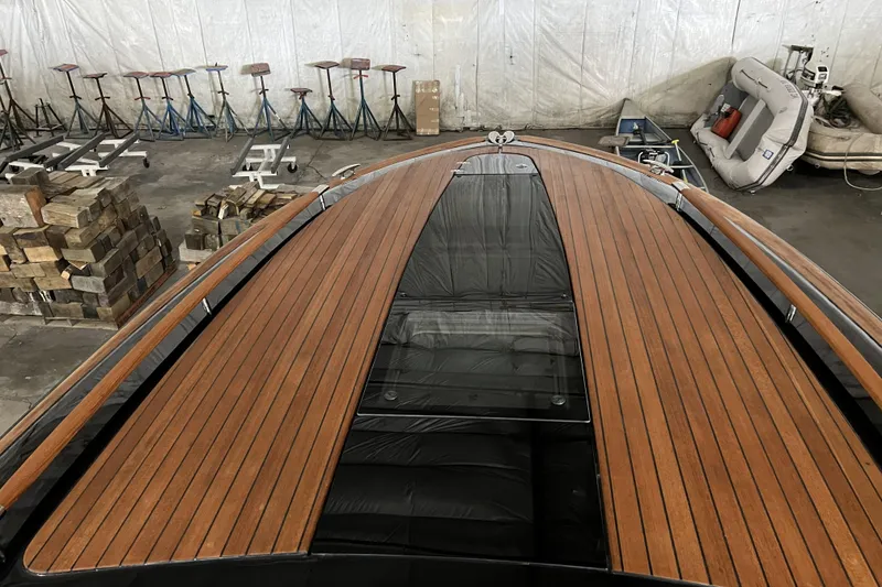 Slide: The Image of 2022 Chris-Craft Corsair 34 boat with sleek wooden deck in a storage facility. - 6