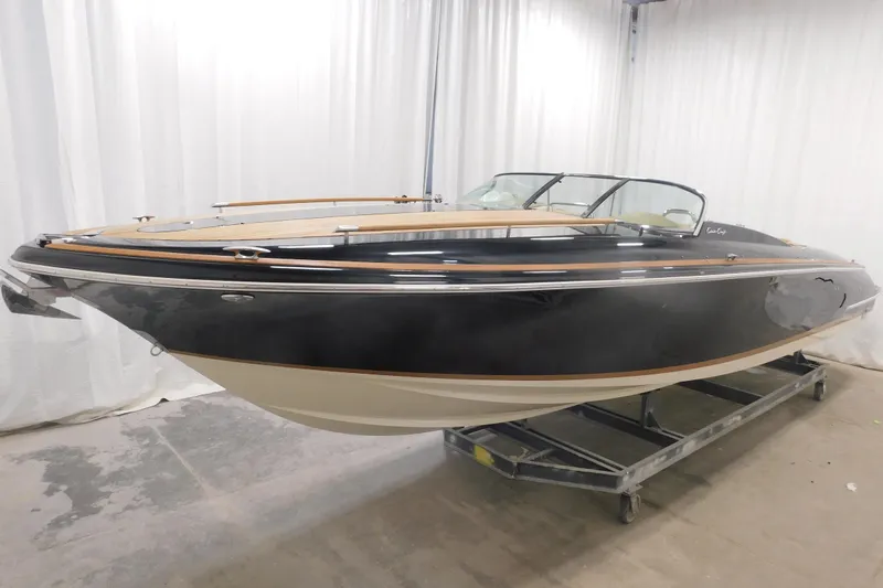 Slide: The Image of 2022 Chris-Craft Corsair 34 boat in showroom, elegant design with sleek black hull. - 7