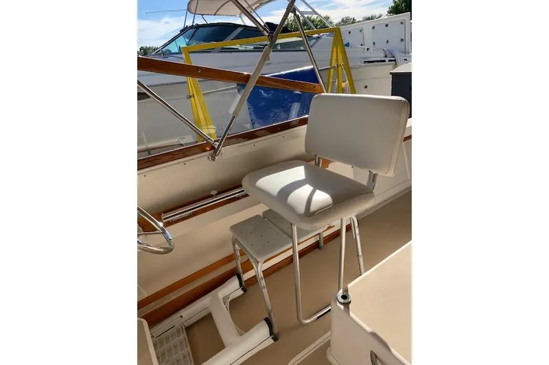 Slide: The Image of 1999 Nauset Downeast Cruiser helm seat with white upholstery and metal frame. - 14
