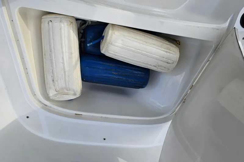 Slide: The Image of Storage compartment with boat fenders on a 1999 Boston Whaler 23 Outrage. - 13