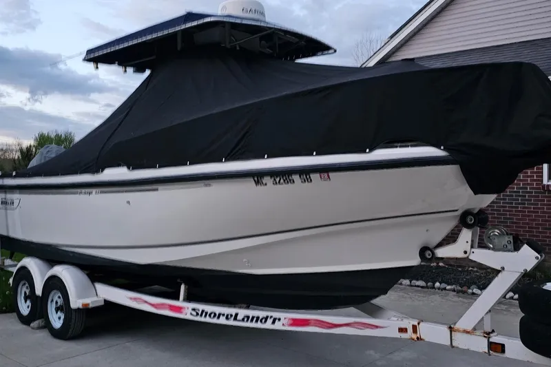 Slide: The Image of 1999 Boston Whaler 23 Outrage boat on trailer, covered with black tarp. - 17