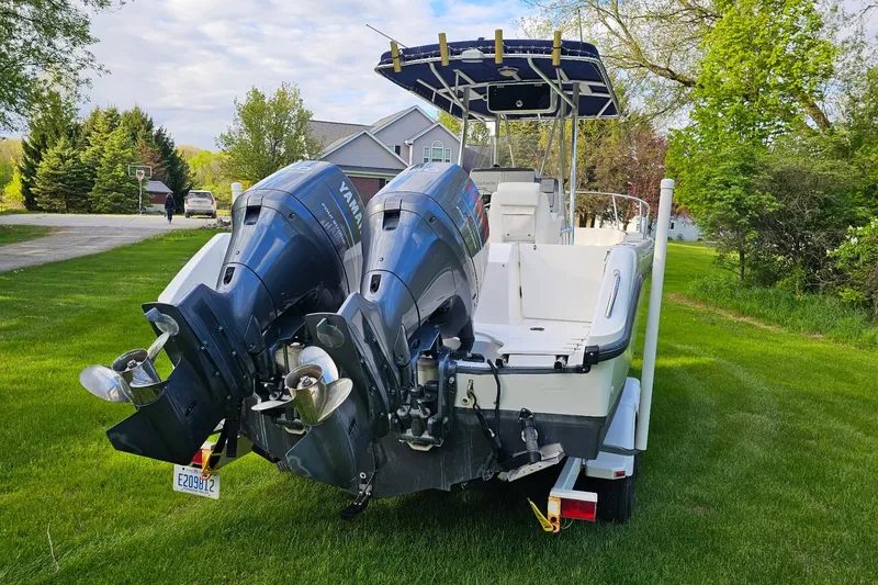 Slide: The Image of 1999 Boston Whaler 23 Outrage boat with dual Yamaha outboard motors on a grassy lawn. - 2