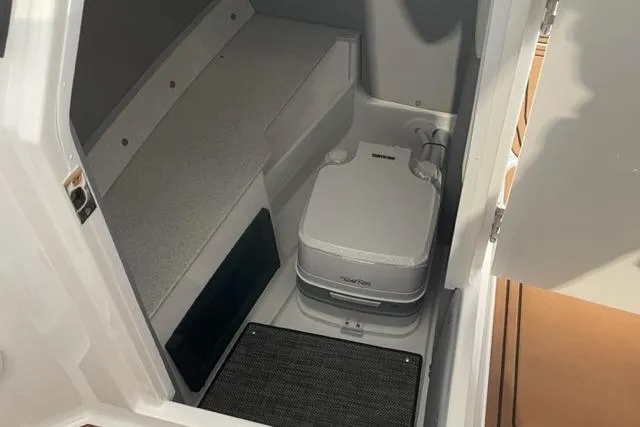 Slide: The Image of 2023 Cobalt R6 Surf boat interior with compact toilet and seating area. - 15