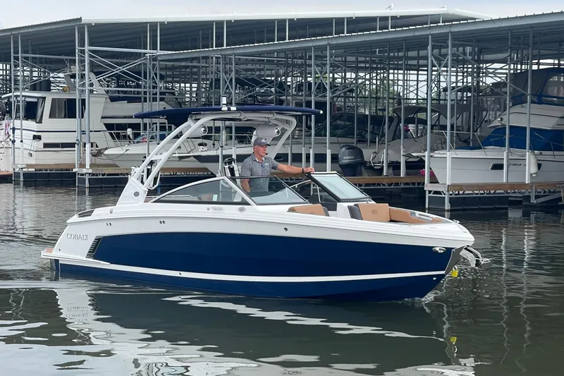 Slide: The Image of 2023 Cobalt R6 Surf boat docked at marina with a person onboard. - 21