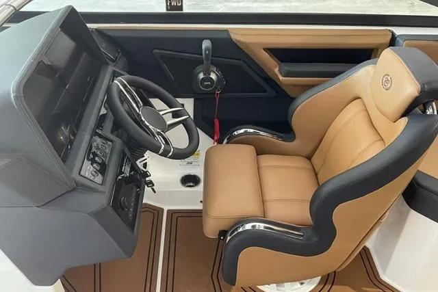 Slide: The Image of 2023 Cobalt R6 Surf boat cockpit with tan leather seat and modern steering controls. - 7
