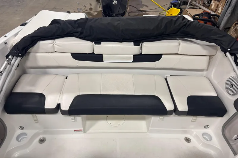 Slide: The Image of 2023 Tahoe 200 S boat interior with white and black seating in a garage setting. - 10