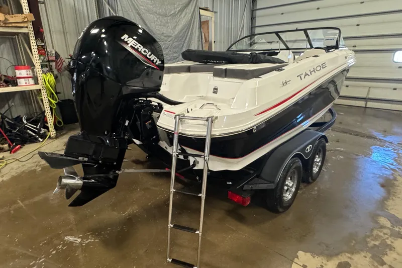 Slide: The Image of 2023 Tahoe 200 S boat with Mercury engine in a garage setting. - 2