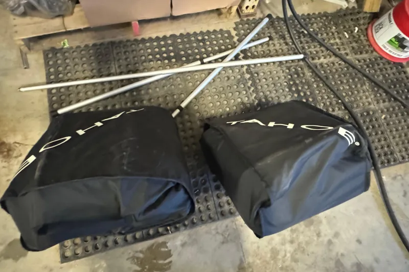 Slide: The Image of Black Tahoe 200 S covers and metal poles on a rubber mat, 2023 model. - 4