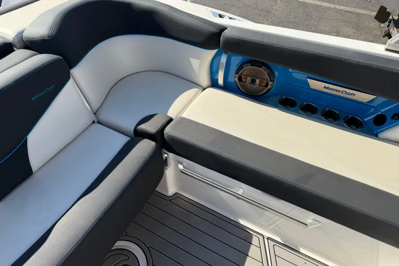 Slide: The Image of 2018 MasterCraft X26 boat interior with cushioned seating and speaker system. - 10