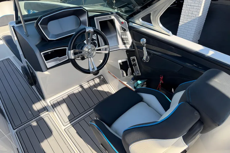 Slide: The Image of Interior view of 2018 MasterCraft X26 boat cockpit with steering wheel and control panel. - 13