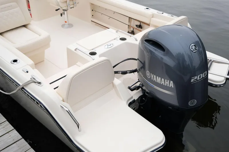 Slide: The Image of 2025 Grady-White Freedom 215 boat on calm water, featuring Yamaha outboard motor. - 2