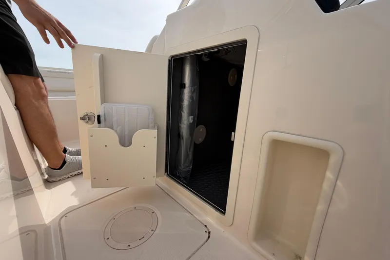 Slide: The Image of 2025 Grady-White Freedom 215 boat storage compartment with open door and visible interior. - 20