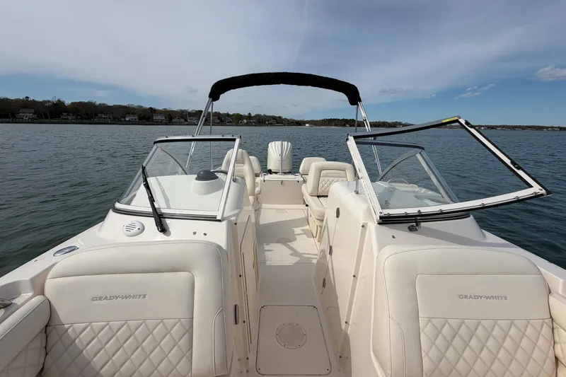 Slide: The Image of 2025 Grady-White Freedom 215 boat on calm water, featuring spacious seating and open deck. - 26