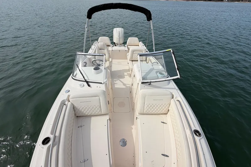 Slide: The Image of 2025 Grady-White Freedom 215 boat on calm water, showcasing spacious seating and sleek design. - 27