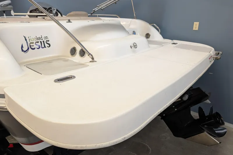 Slide: The Image of 2013 Hurricane SunDeck Sport 201 IO boat with "Hooked on Jesus" decal on the stern. - 2