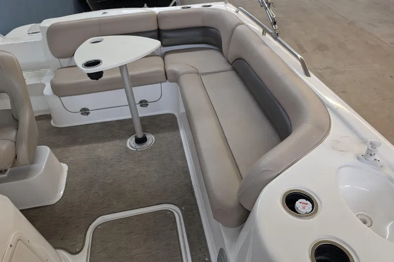 Slide: The Image of 2013 Hurricane SunDeck Sport 201 IO boat interior with beige seating and small table. - 5