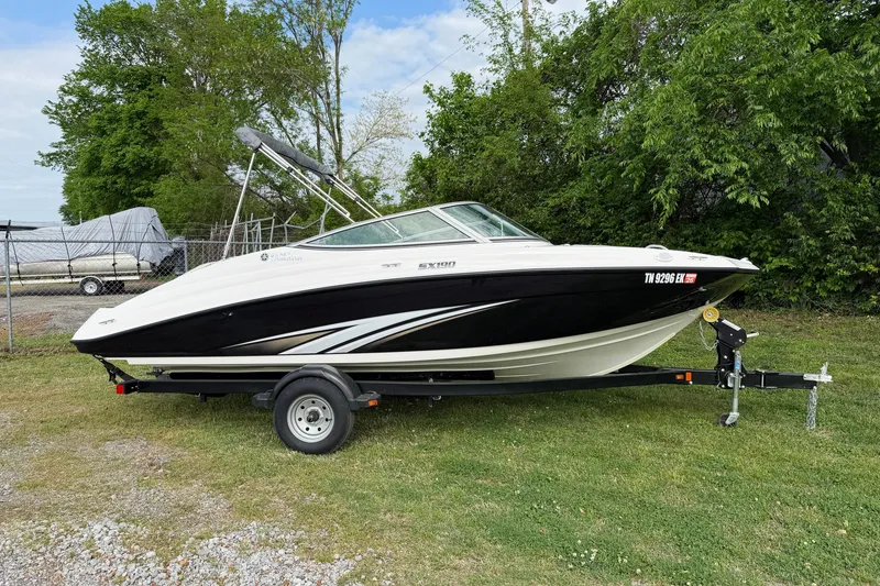 The Image of 2016 Yamaha Boats SX190 on trailer, parked on grass with trees in background. - 1