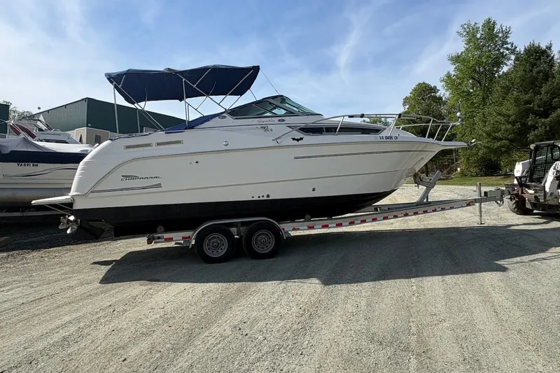The Image of 2000 Chaparral Signature 270 boat on trailer under cloudy sky. - 0