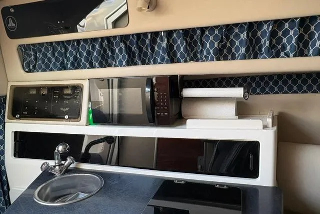 Slide: The Image of 2000 Chaparral Signature 270 boat bathroom with sink, toilet, and storage compartments. - 16
