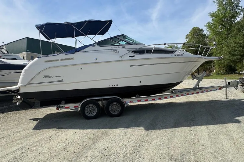 Slide: The Image of 2000 Chaparral Signature 270 boat on trailer, parked near a lake. - 3