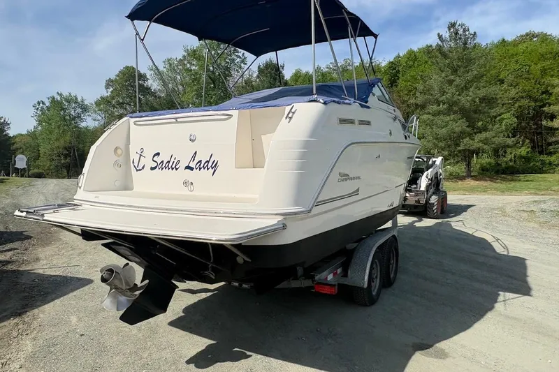 Slide: The Image of 2000 Chaparral Signature 270 boat on trailer, featuring a blue canopy, parked outdoors. - 5
