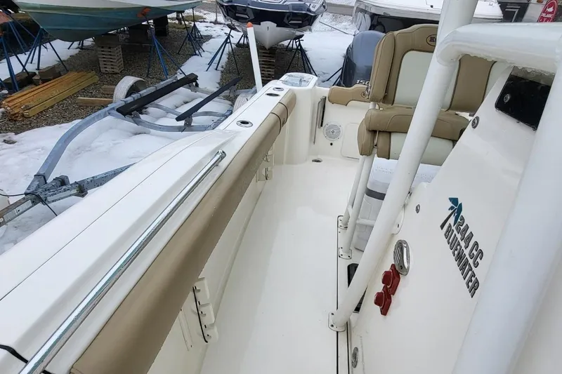 Slide: The Image of 2019 Key West 244 Center Console boat interior with seating and storage, parked on snowy ground. - 10