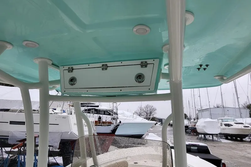 Slide: The Image of 2019 Key West 244 Center Console boat with teal interior and docked yachts in background. - 15