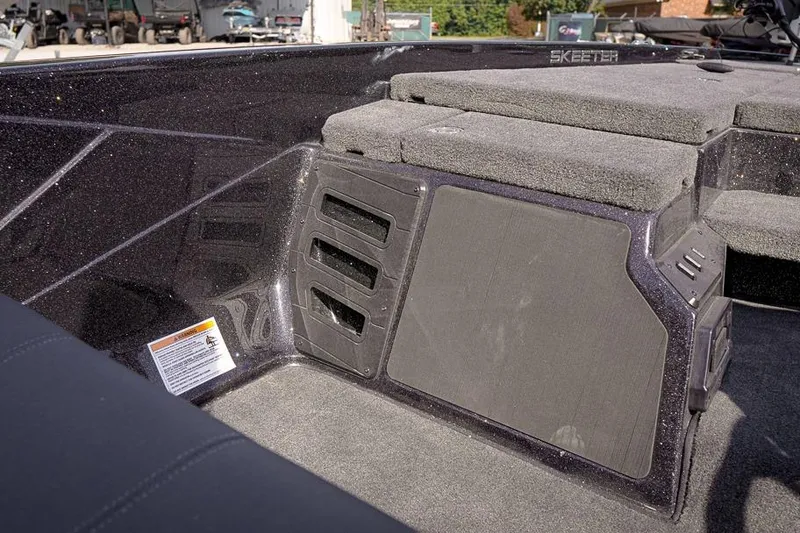 Slide: The Image of 2026 Skeeter ZX200 boat interior with carpeted seating and storage compartments. - 19