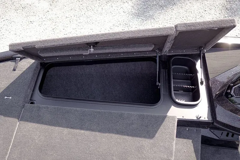 Slide: The Image of Open storage compartment on 2026 Skeeter ZX200 boat, featuring carpeted interior and organized sections. - 26