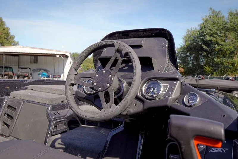 Slide: The Image of 2026 Skeeter ZX200 boat dashboard with steering wheel and gauges in outdoor setting. - 7