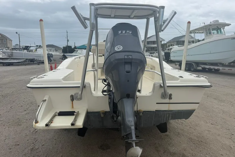 Slide: The Image of 2001 Scout 185 Sportfish boat with Yamaha 115 outboard motor, parked on gravel. - 4