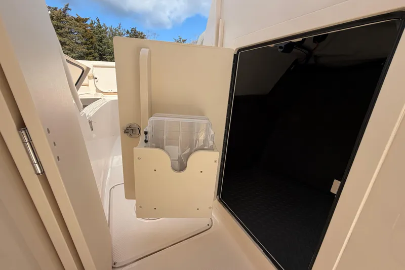 Slide: The Image of 2025 Grady-White Freedom 235 boat interior storage compartment with open door. - 17