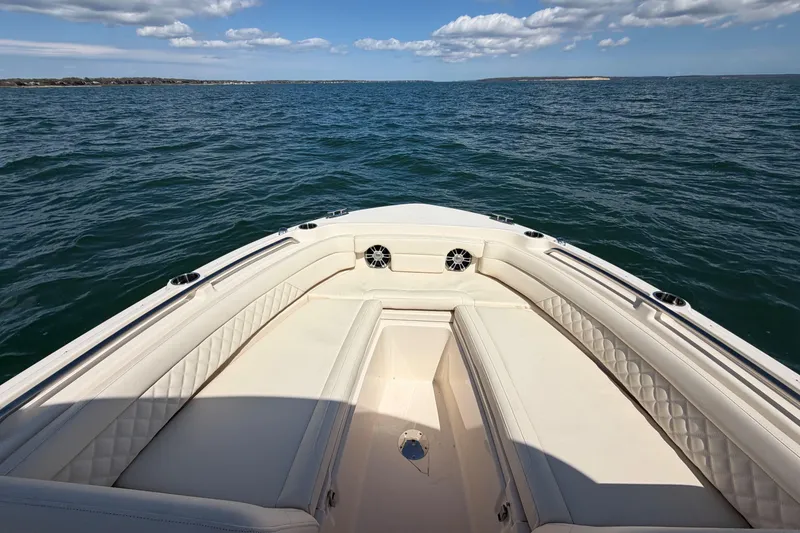 Slide: The Image of 2025 Grady-White Freedom 235 boat on open water, featuring spacious seating and clear skies. - 18