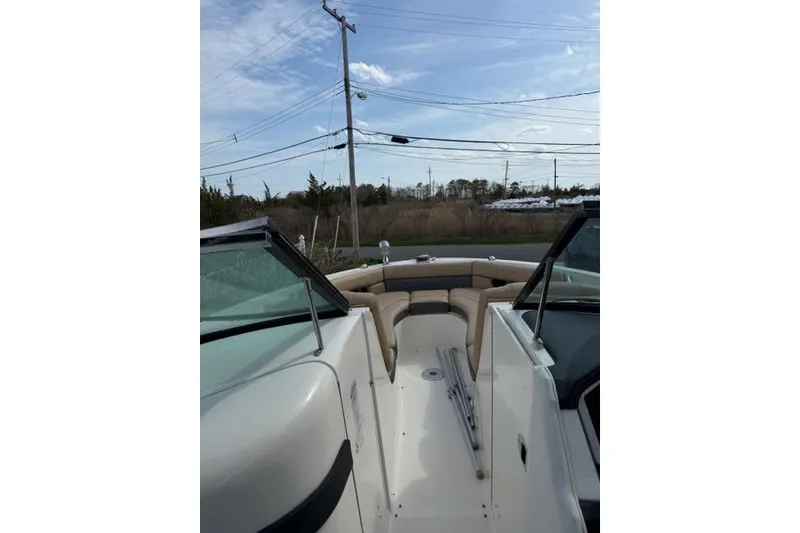 Slide: The Image of 2015 Sea Ray 300 SLX boat interior with beige seating, under a clear blue sky. - 5