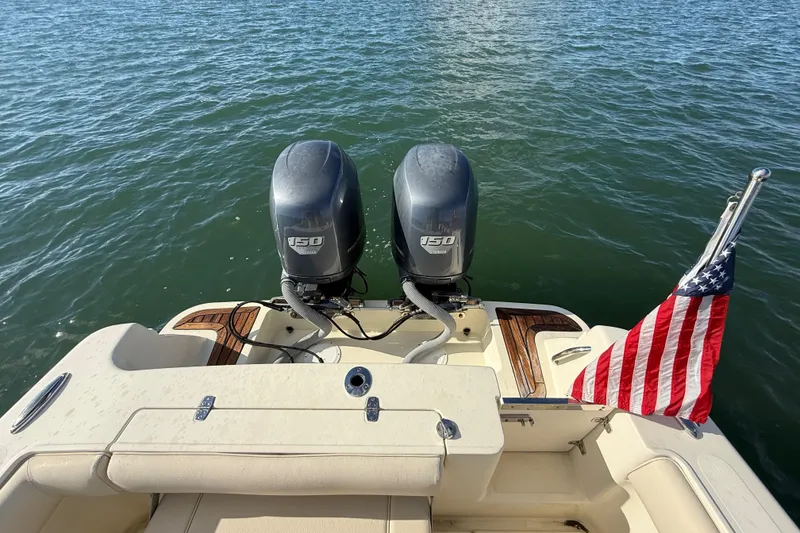 Slide: The Image of 2013 Chris-Craft Catalina 26 with twin 150 engines and American flag on water. - 19