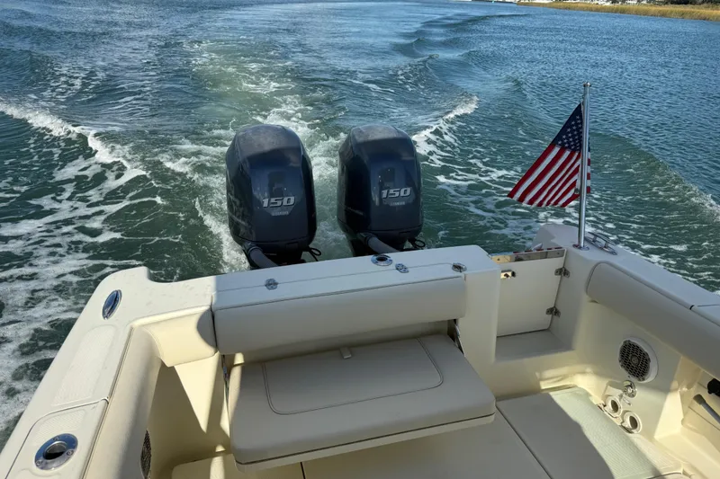 Slide: The Image of 2013 Chris-Craft Catalina 26 with dual engines and American flag on open water. - 24