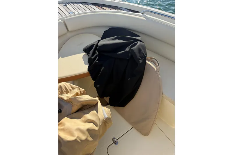 Slide: The Image of 2013 Chris-Craft Catalina 26 boat interior with cushions and clothing on deck. - 30