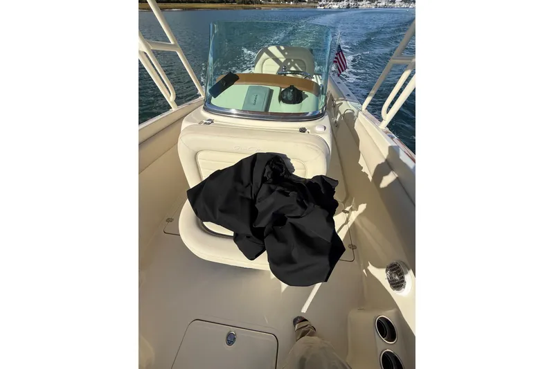 Slide: The Image of 2013 Chris-Craft Catalina 26 boat interior with seating and American flag on water. - 31