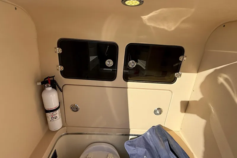 Slide: The Image of Interior of 2013 Chris-Craft Catalina 26 with storage compartments and fire extinguisher. - 34