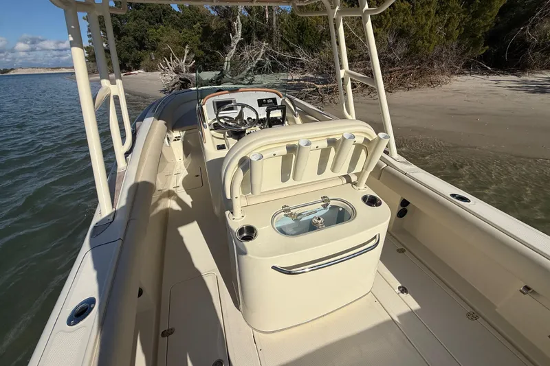 Slide: The Image of 2013 Chris-Craft Catalina 26 boat interior with fishing rod holders, near sandy shore. - 36
