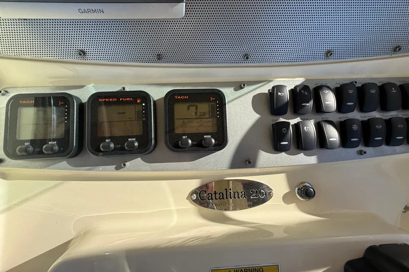 Slide: The Image of Dashboard of a 2013 Chris-Craft Catalina 26 with gauges and control switches. - 38