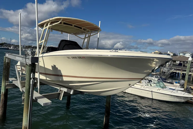 Slide: The Image of 2013 Chris-Craft Catalina 26 boat on lift, docked by marina under blue sky. - 7